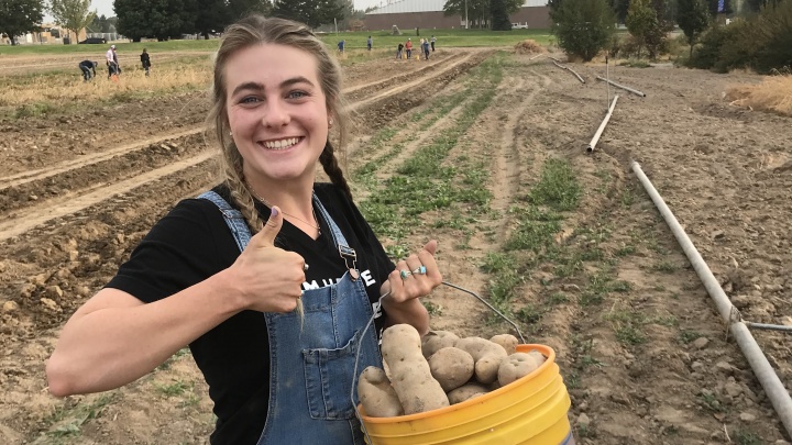 girl farming smiling thumbs up overalls
