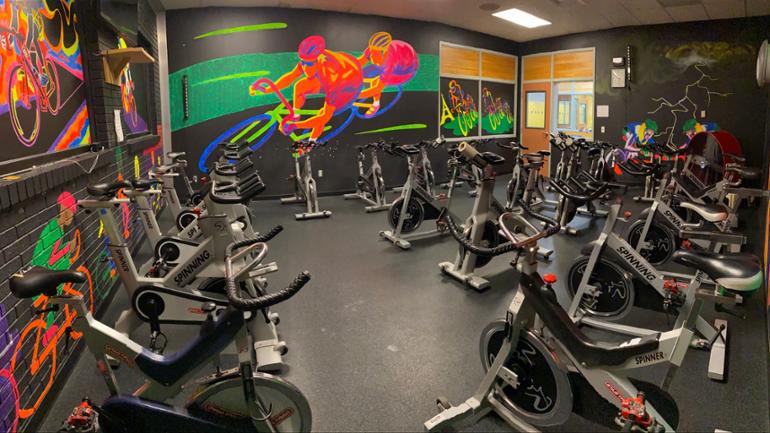 spin room with many stationary bikes for classes