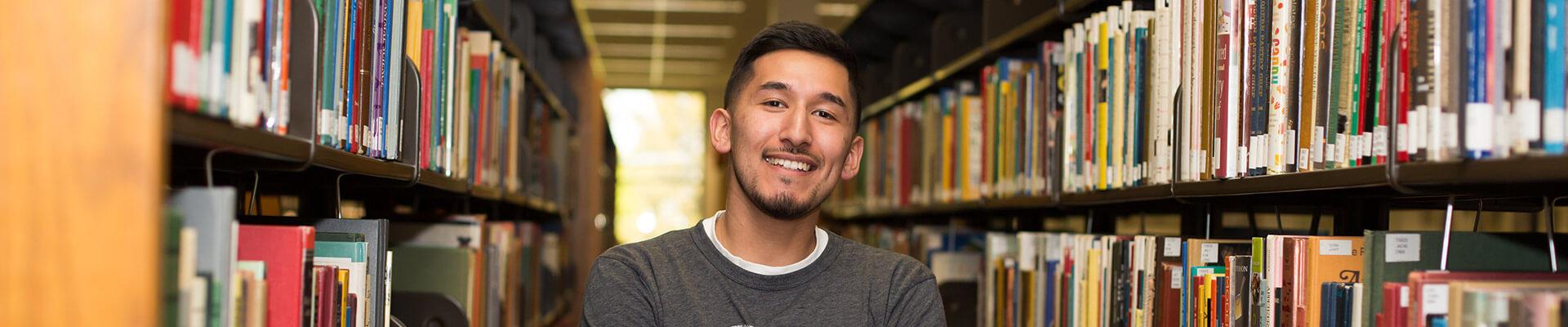 Student standing in the CSI library. 