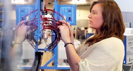 woman checking machine wiring