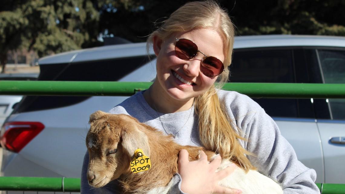 student holding baby goat