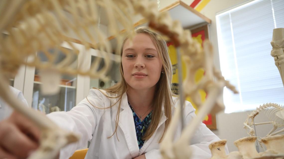 student with skeleton in lab