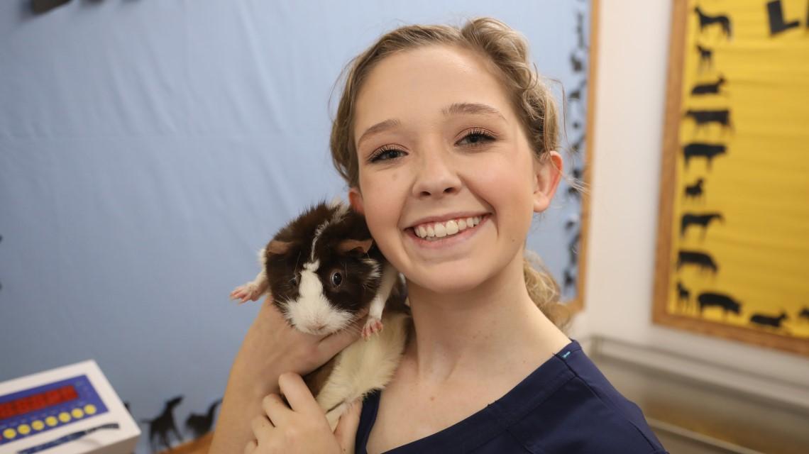 student holding guinea pig