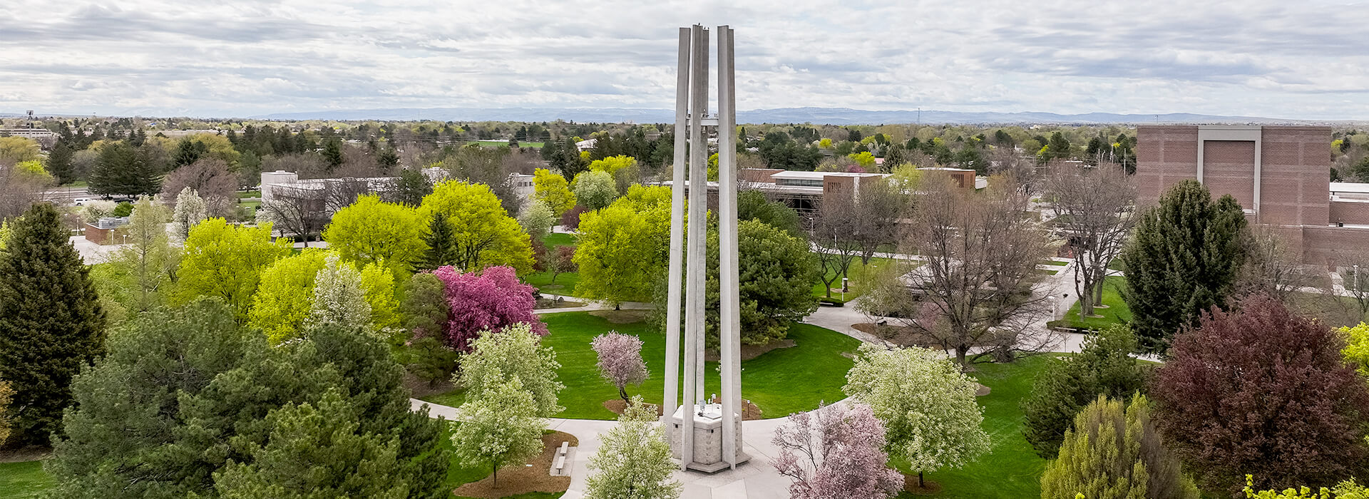 aerial photo of the campus with the bell tower, gym building and evergreen building in the background