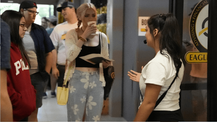 students in hallway with coffees talking