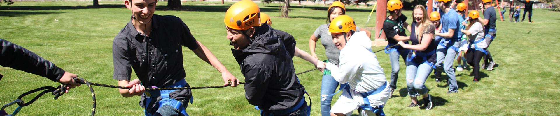 students pulling a rope during tug-of-war to promote teamwork 