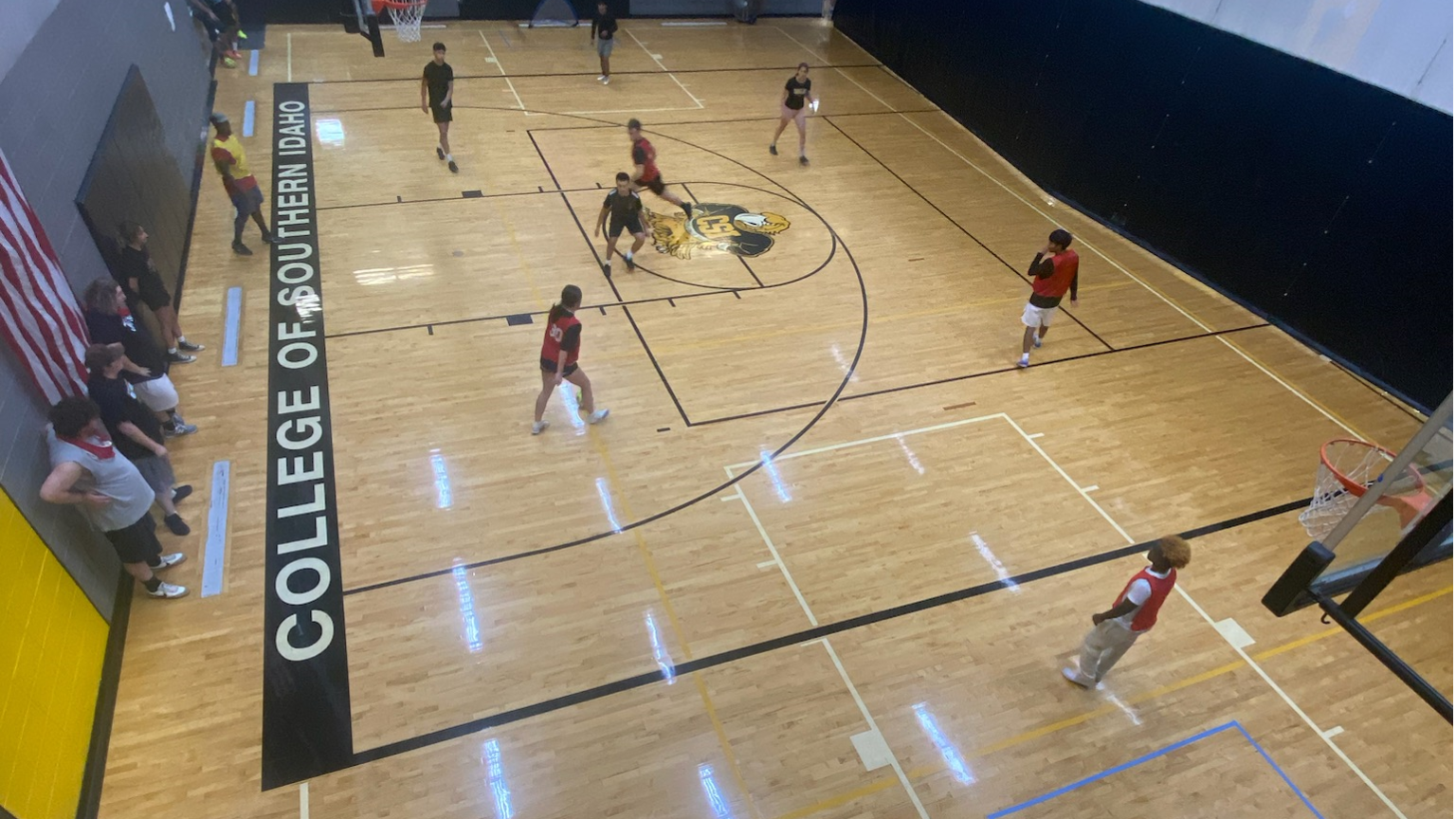 Top down view of students playing basketball in the CSI gym