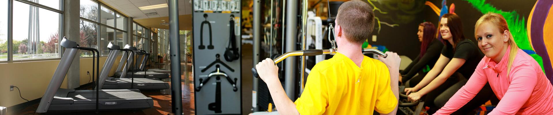 student pulling down weights with students on riding stationary bikes