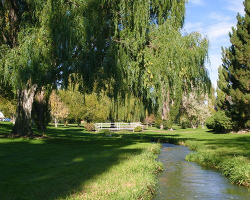 creek with white picket fence in background