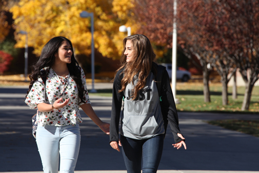 Image of two CSI students walking across campus in the fall.  