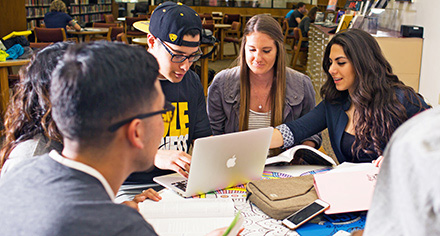 An image showing CSI students gathered around a table.