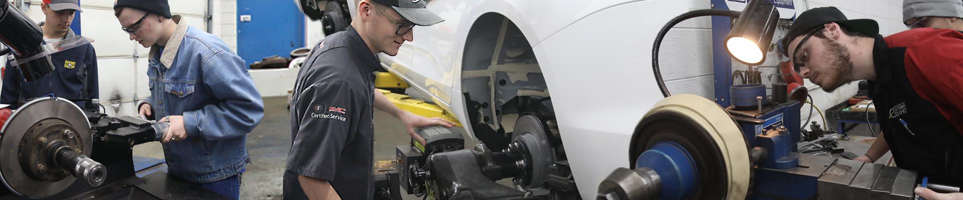 Four automotive students working on a vehicle